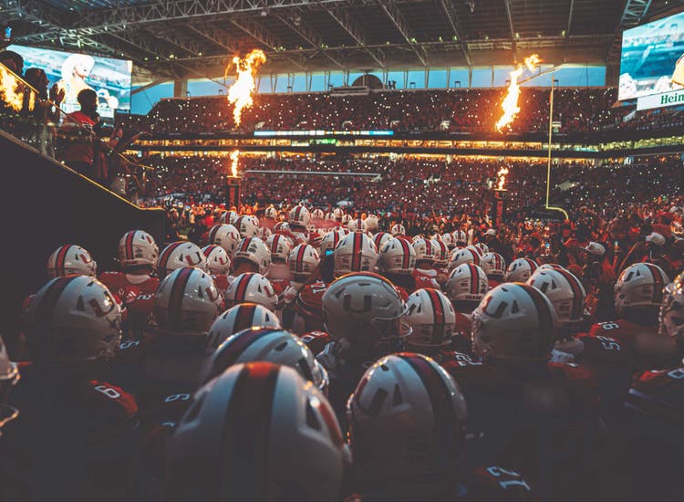 An image of University of Miami football players preparing to take the field.