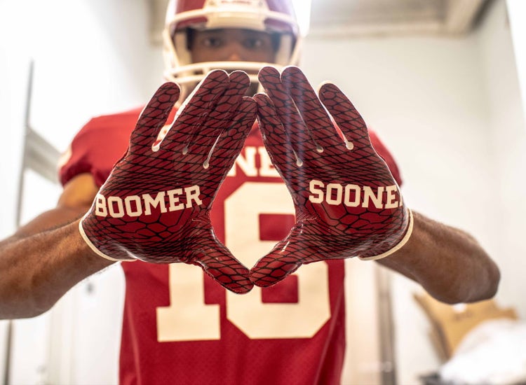 An image of an Oklahoma player with "Boomer Sooner" gloves.