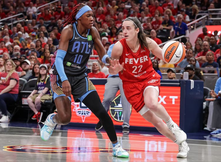 Indiana Fever star Caitlin Clark drives on Atlanta Dream defender Rhyne Howard.